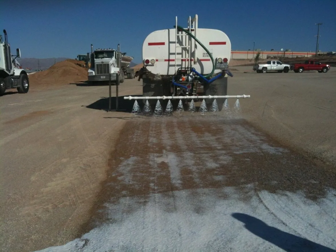 A water truck spraying diluted product onto prepared road base through a rear spray bar